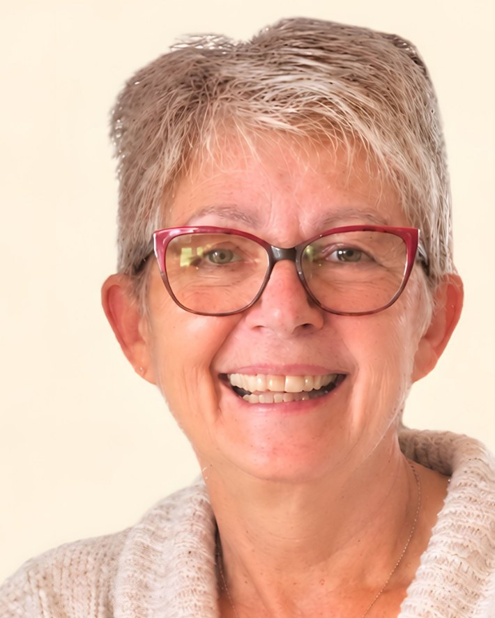 Porträt von Rita Bülow: lächelnde Frau mit kurzem grauem Haar und roter Brille.